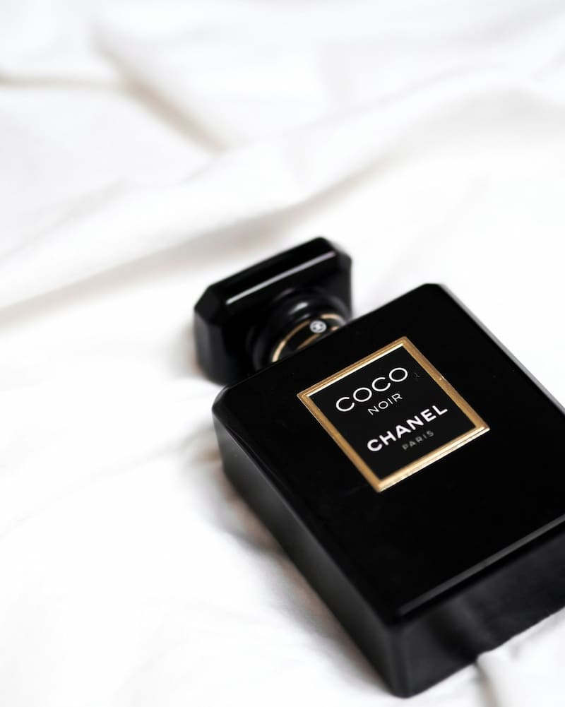 Black Chanel bottle on bed