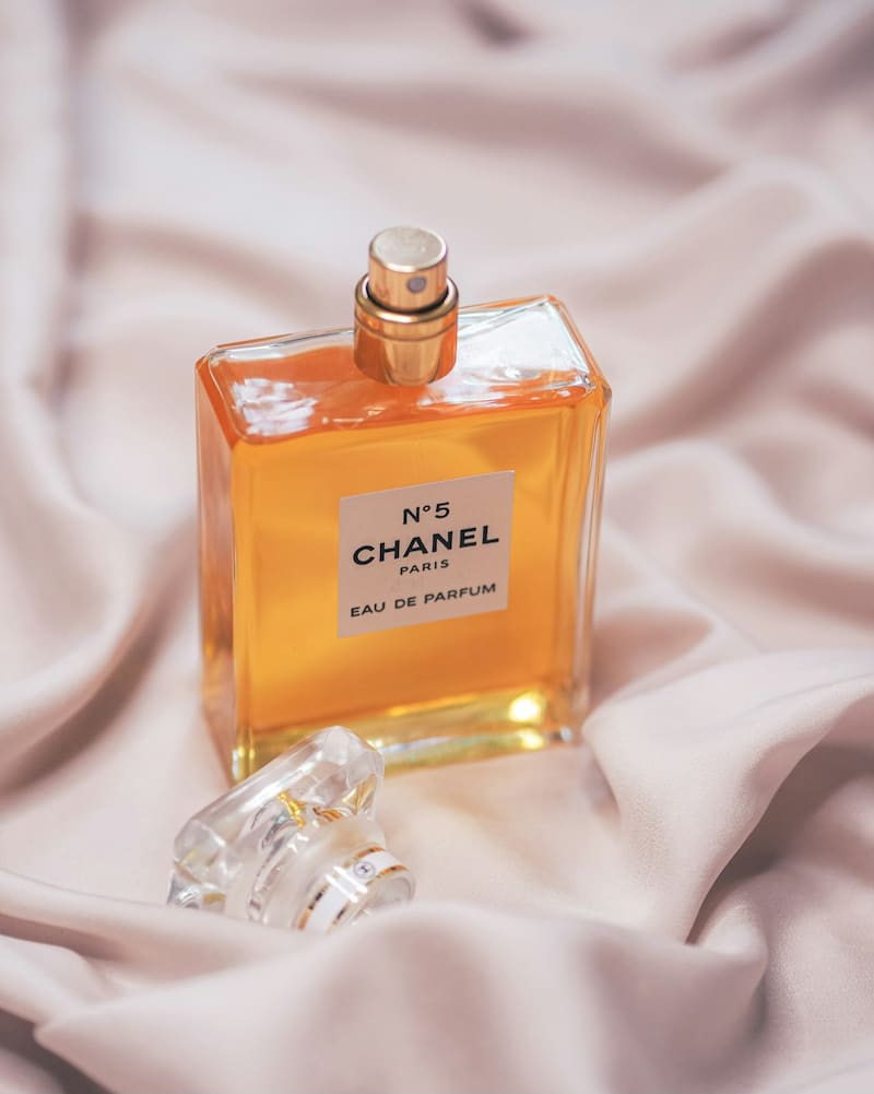 Gold bottle of Chanel No. 5 on bed